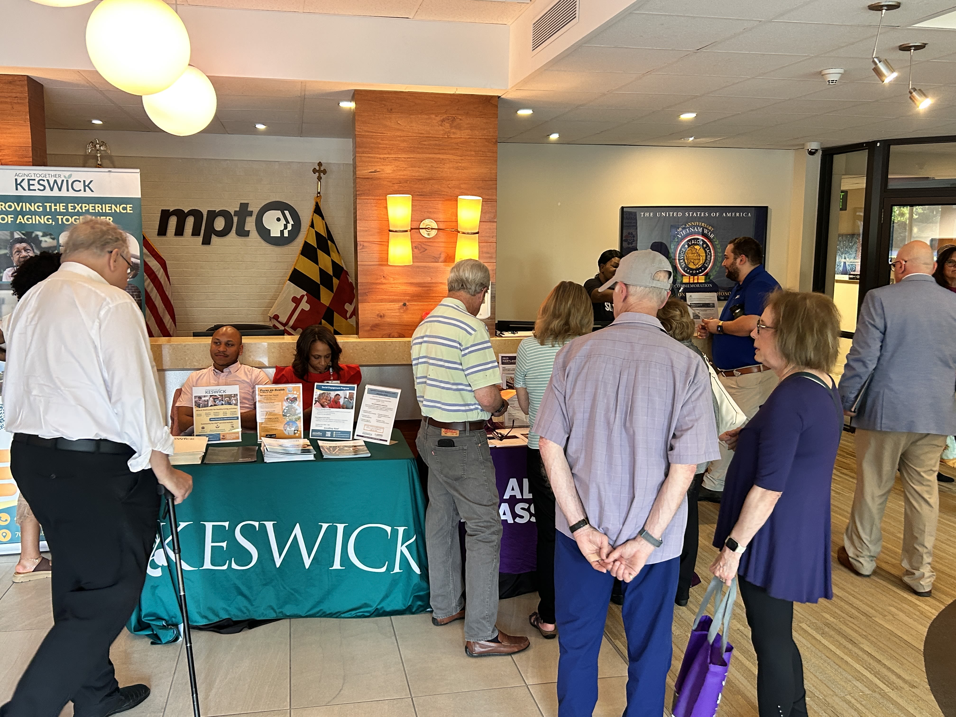 Image of people talking and visiting booths at an event.